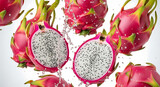 Vibrant dragon fruit halves and whole fruits with water splash against white background.