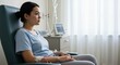© Andrey - Young woman receiving treatment while sitting in a hospital chair.  chemo patient sitting in hospital chair