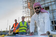 © Jack Tamrong - Arabic project investor in traditional arab cloth discussing with male house contractor and builder in construction site