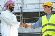 © Jack Tamrong - Arabic building project investor shaking hands  with male contractor in construction site