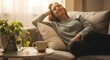 © Richafuji - Relaxed woman enjoying a moment of peace indoors with a cup of steaming beverage on a table beside a plant. Soft lighting and a cozy atmosphere enhance the sense of tranquility.