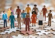 © Leonardo - Grupo de diversas personas recortadas en papel paradas sobre piezas de rompecabezas interconectadas, simbolizando la inclusión y el trabajo en equipo