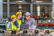 © BESTIMAGE - Friendly group of diverse industrial engineers wea yellow safety helmets and reflective vests discussing a project with a senior engineer in a manufactu factory setting