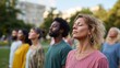 © fotofabrika - Group of individuals practicing mindfulness meditation outdoors in a park during sunset in an urban environment