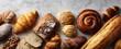 © Marta B - The delightful assortment of freshly baked artisanal breads and pastries on a textured surface.