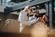 © qunica.com - People engaging in a productive business discussion in an urban outdoor setting on a sunny day. They hold digital devices while talking and recording notes, reflecting collaboration and innovation.