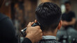 © Rajat - Close-up of Indian barber's hands using a trimmer on a male customer's hair, with only the back of the head visible, captured in warm light with mirror blur, evoking a calm salon moment.