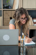 © simona - Professional young woman working in modern office with laptop and desktop computer – focused business environment, digital work, smart working and technology concept