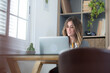 © simona - Professional young woman working in modern office with laptop and desktop computer – focused business environment, digital work, smart working and technology concept