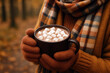 © DailyStock - Warm beverage with marshmallows held by gloved hands wearing a plAId scarf hot chocolate