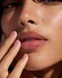 © CLARET - Woman's face close up highlighting glossy lips and smooth skin in natural light