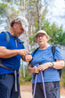 © MiguelAngel - Man with senior woman checking the smartwatch enjoying a hiking day.