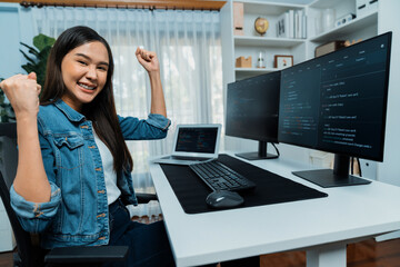 Wall Mural - young asian it developer creating raising fist up with successful information on pc with coding prog