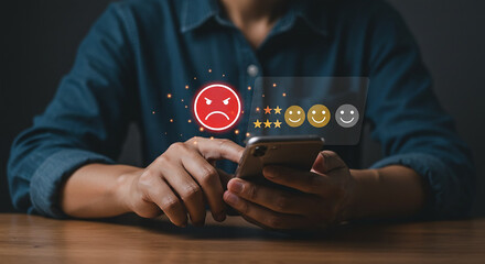 Person using smartphone to give a negative review with an angry face and stars on the screen display