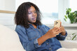 © New Africa - Woman unlocking her smartphone with facial recognition app at home. Biometric verification