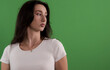 © 4kclips - Studio shot of a young woman wearing a white t shirt and looking away against a chroma key background