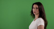 © 4kclips - Young woman with long brown hair wearing white shirt is posing on green screen background