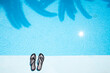 © Matteo Colombo - Pair of slippers on the edge of the swimming pool from above