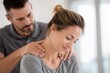 © ttonaorh - Young male physical therapist working with a female patient in a clinic office, holding her neck and shoulder for pain treatment at work.