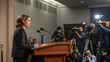 © Wave - Serious businesswoman giving press conference at podium