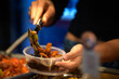 © Natsky - Take away stir fry food being served into a container by hand