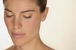© fStop - Close up portrait of beautiful, serene woman with freckles and eyes closed against white background