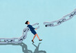 © fStop - Businesswoman attempting to reconnect broken chain against blue background