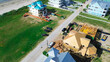 © trongnguyen - Aerial view residential construction near ocean shoreline with framing work, roofing, heavy equipment, and sandy terrain, vacant land, energy and scale of active development in Galveston, Texas
