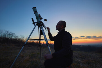 Wall Mural - amateur astronomer using telescope and smartphone for watching stars, moon, planets and other celest