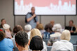 © Anton Gvozdikov - Unfocused view of an audience listening to a speaker during an educational event or presentation.