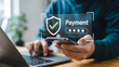 © Shamim - Person uses mobile payment authentication on a laptop for secure online shopping transaction, completing digital banking with smartphone verification and account protection.
