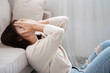 © doucefleur - Sad Asian woman struggling with mental health issues, covering face  and feeling anxious, depressed, and emotionally overwhelmed, staying alone at home ,signs of psychological trauma or mental illness
