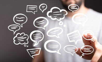 Image of a man interacting with digital chat bubbles, symbolizing communication, social media, or online conversation.