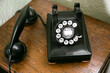 © Tetra Images - Black antique rotary phone on wooden table