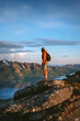 © EVERST - Man hiking solo in Norway standing on cliff above fjord active travel adventure lifestyle, tourist walking alone in mountains summer vacations backpacking trip in the wild