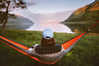 © EVERST - Man relaxing alone in hammock travel lifestyle summer vacations outdoor in Norway, traveler enjoying calm sunset view of mountains and fjord harmony and freedom eco tourism camping trip
