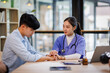 © David - Compassionate Asian Nurse Offering Comfort by Connecting Hands at a Healthcare Facility