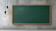 © Helena - Empty green chalkboard in a wooden frame on a grey concrete wall with two hanging light bulbs.
