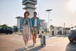 © Drazen - Carefree couple with luggage on parking lot at the airport.