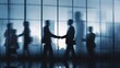 © Harry - Business agreement concept showing blurred silhouette of business people shaking hands near large window in office building showing blurry cityscape.