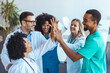 © Dragana Gordic - Group of Medical Professionals Celebrating Success With a Team High-Five