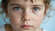 © Lubov - Close-up portrait of young freckled child with bright blue eyes. Child nose, chin slightly turned to left. Soft focus on skin. Natural expression of innocence, youth. Freckled face with blue eyes.