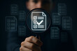 © FAQIR - Close-up of hand holding magnifying glass focusing on digital checklist icon, symbolizing document validation, quality assurance, and auditing process in modern digital workflow