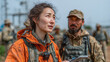 © Ihsanfir - Woman in orange jacket with military personnel reflects on global compact principles and cooperation