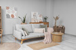 © Pixel-Shot - Interior of light room with cozy sofa, coffee table and pictures on wall