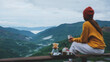 © Farknot Architect - Rear view of a woman drinking drip coffee while sitting on wooden terrace and looking at a mountain view