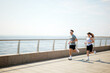 © muse studio - Morning joggers enjoy a refreshing run along a coastal promenade at dawn