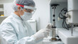 © Qrryferry - In a laboratory setting, a healthcare worker wearing protective gear inspects equipment carefully. This scene highlights the diligence and safety measures in medical research environments