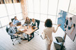 © deagreez - Business professionals attending an engaging presentation in a modern office setting, highlighting teamwork and collaboration