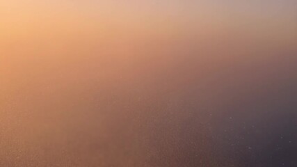 Wall Mural - City lights emerging through dissipating fog, revealing urban skyline with soft gradient colors during sunset, creating atmospheric and mysterious twilight scene